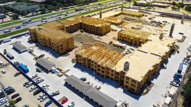 istock Apartment under construction near Interstate I-35E Stemmons Freeway downtown Dallas, timber wood frame, elevator vertical shaft, large courtyard, slab foundation, heavy equipment, aerial view 2156010435