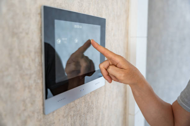 istock View of hand of man using tablet panel application for control smart home living. Wireless device controller for home automation IoT on the wall 2156010775