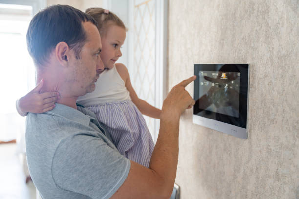 Daughter in her father using tablet panel application for control smart home living. Wireless device controller for home automation IoT on the wall Daughter in her father using tablet panel application for control smart home living. Wireless device controller for home automation IoT on the wall. High quality photo air conditioner family stock pictures, royalty-free photos & images