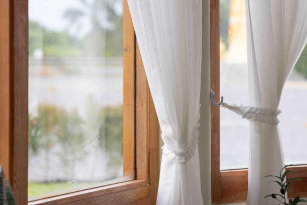 istock The curtains are white and hanging in front of a window 2156011330