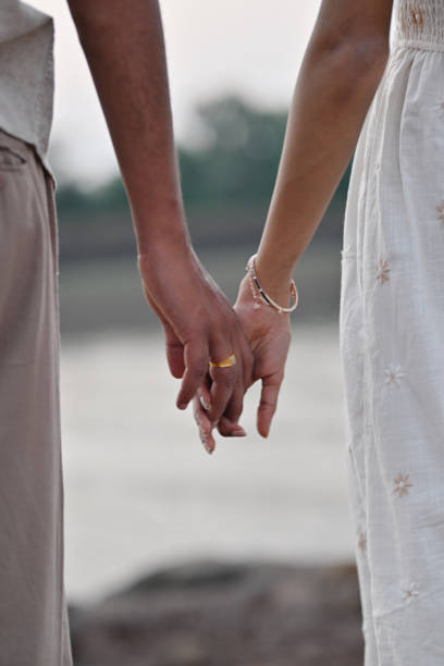 istock Cropped interwined hands of a young couple 2156012693