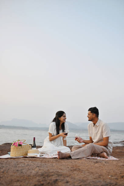 istock Young couple enjoying wine by the lakeside 2156012713