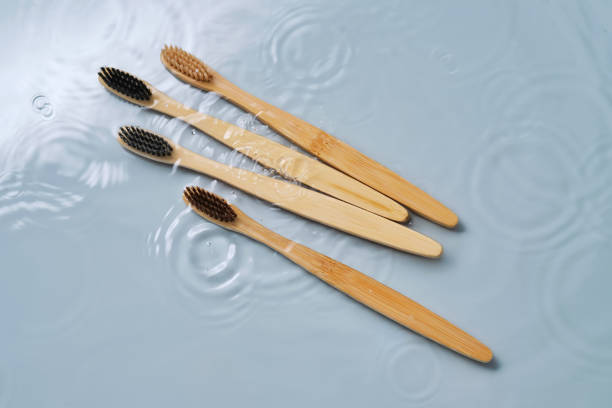 istock Natural bamboo toothbrushes in water on a blue background. 2156012725