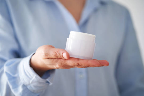 istock Hands in a blue shirt hold a jar of cream. 2156013217