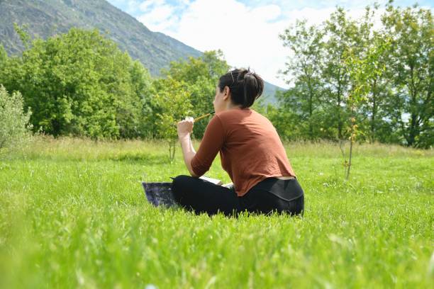 istock Smart working girl with laptop in a green field 2156013618