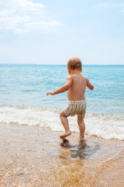 Little male child playing on the beach in Greece.
