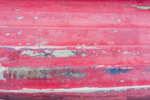 Weathered base of a rowboat on dry land.