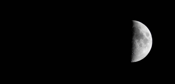 istock Half moon during the first quarter phase isolated against a black sky. 2156016805