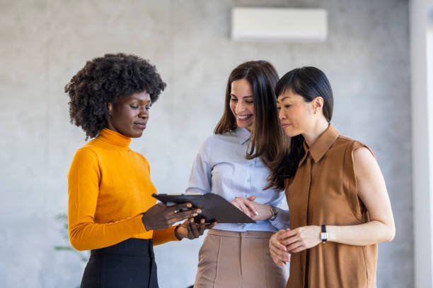 istock Diverse Team of Businesswomen Analyzing Data on Clipboard 2156017623
