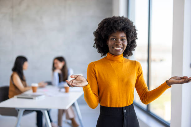 istock Smiling Black Businesswoman Presenting in Modern Workspace 2156017666