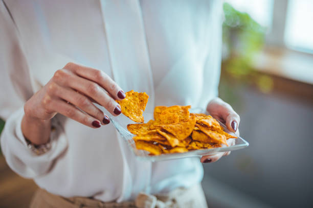 Professional Woman Savoring Tortilla Chips at Work