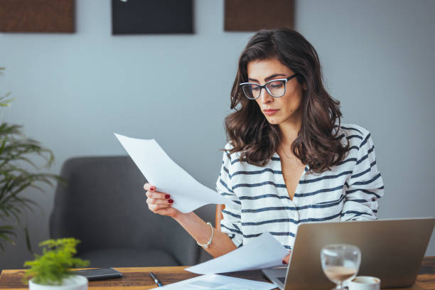 istock Professional Woman Reviewing Documents in Office Setting 2156018050