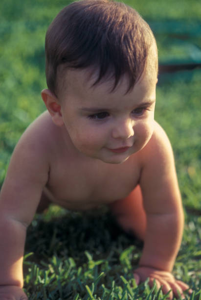 istock Baby boy crawling on the grass in the backyard 2156018163