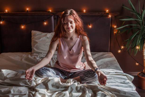 istock Peaceful young active woman practicing yoga on the bed 2156018473