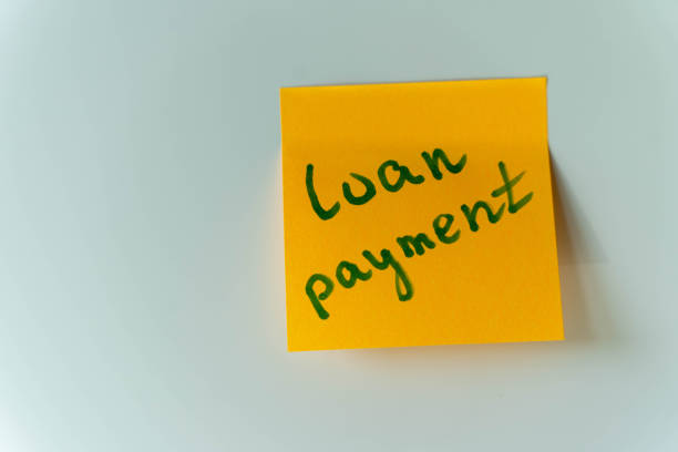 istock A yellow sticky note with Loan Payment written in green pen on a white background 2156020767