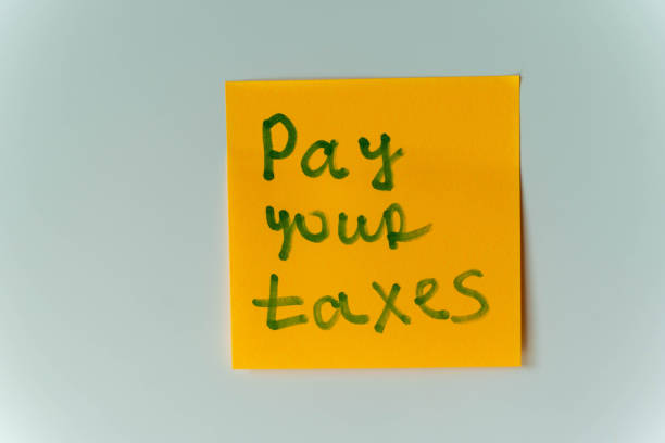 istock A yellow sticky note with the handwritten message Pay Your Taxes 2156020776