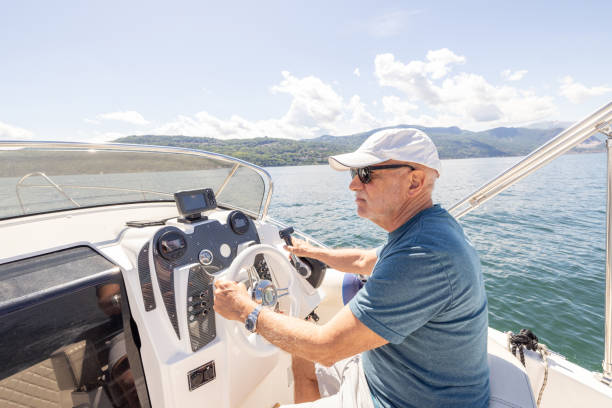 istock Man in his 60's driving a boat on lake 2156024146