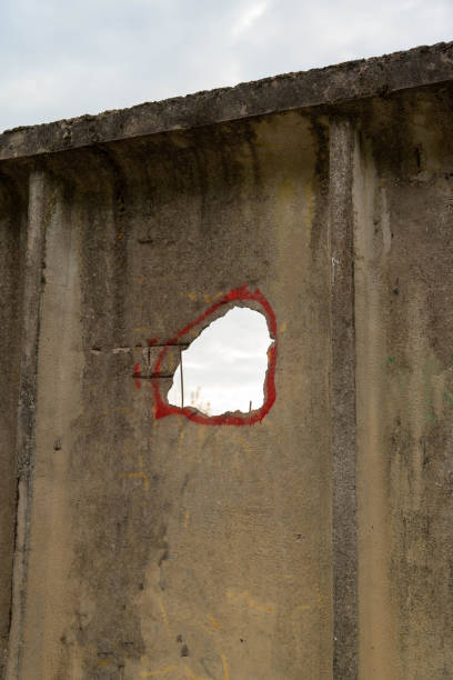 istock A hole in a concrete fence with a red circle drawn around it 2156026433
