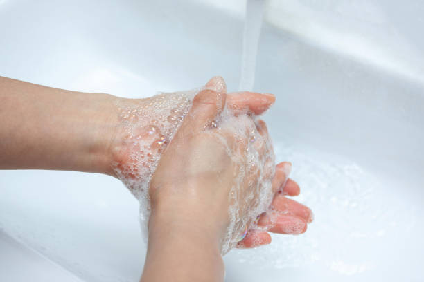 Person washing hands with clear water