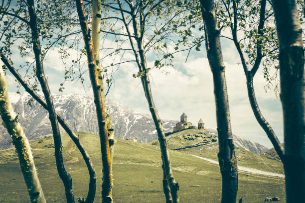 Gergeti Trinity Church, Stepantsminda, Mtskheta-Mtianeti, Georgia. Summer trees and flora in Georgia