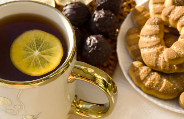 Chocolates and a cup of tea with lemon. Delicious dessert for breakfast.
