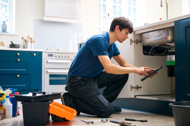 istock Male Plumber With Digital Tablet Fixing Waste Disposal Unit In Domestic Kitchen Sink 2156036375