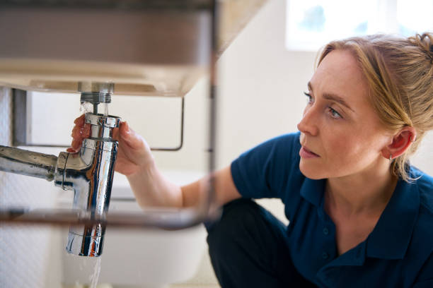 istock Female Plumber Fixing Leak In Domestic Bathroom Sink Or Basin 2156036680
