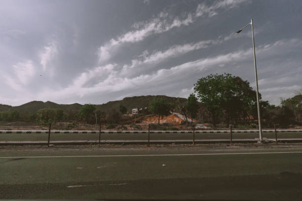 A vast hill seen from a road on a cloudy da y