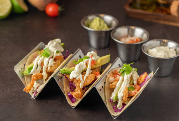 Closeup of tacos arranged on a black countertop