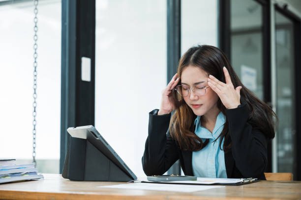 istock Businesswomanman is seriously stressed and upset working on tablet and document paperwork and headache due to office syndrome on laptop and paperwork in the office. 2156039255