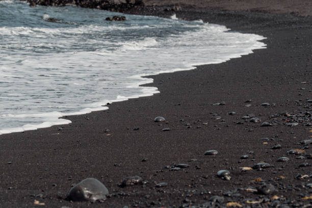 istock Detail of shallow waves on a black beach 2156042169