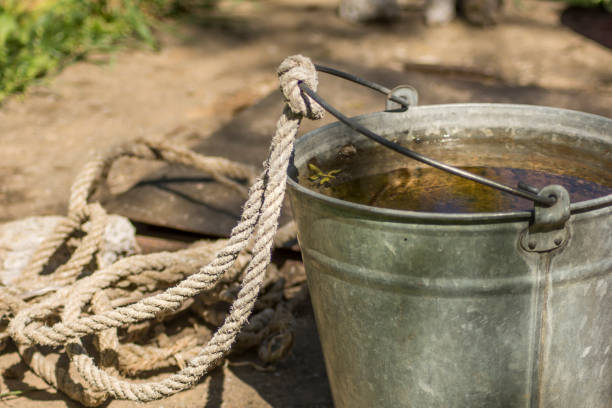 A metal bucket with rope and water inside