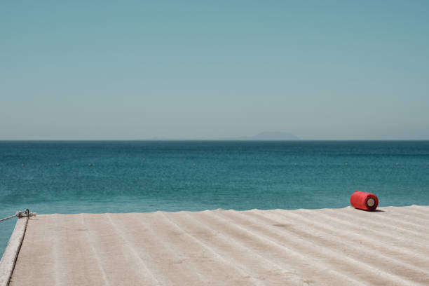 a small red loudspeaker on a roof by the sea