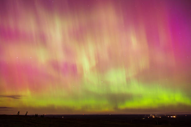 istock Borealis illuminating the sky above field 2156044076