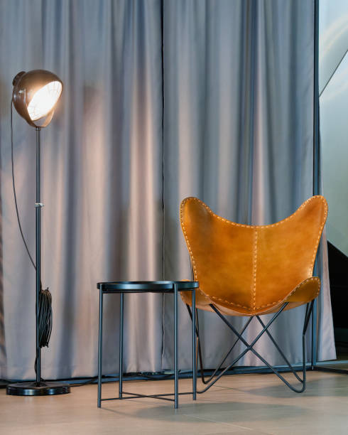 istock Leather chair placed near a table beside a lamp 2156046129