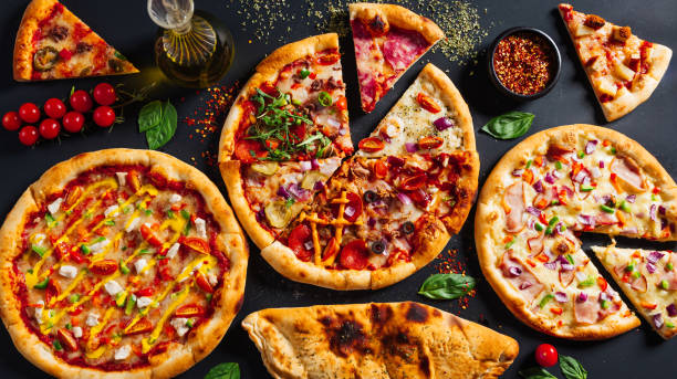 istock pizzas and beer, on a black table with red peppers, cheese, peppers 2156049866