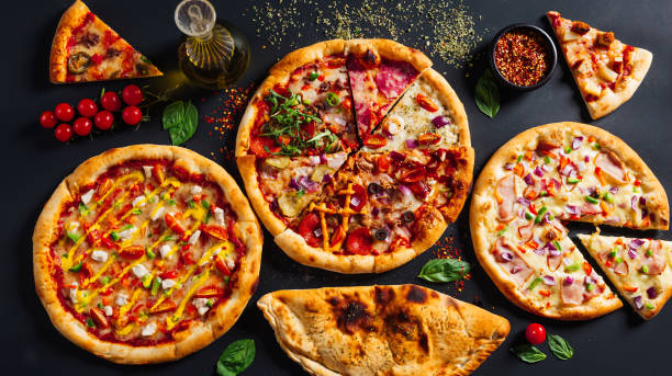 istock four large pizzas, three pepperoni and one chicken on a black table 2156049876