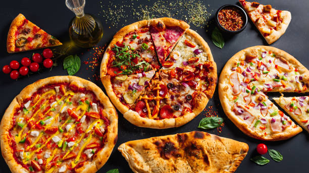 istock different pizzas on top of a black surface with sauce 2156049936