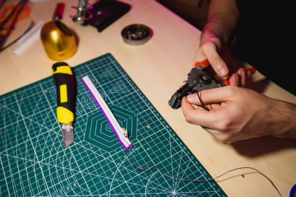 istock Craftsman cutting wires near flex neon on self-healing cutting mat and tools in workshop 2156050709