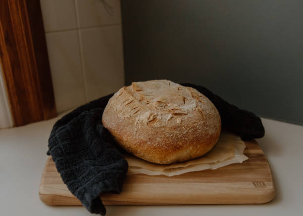 istock Bread loaf on cutting board with nearby towel 2156051825