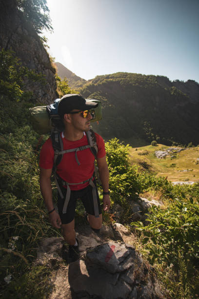 istock Man hiking with a backpack on a mountain trail. 2156052585