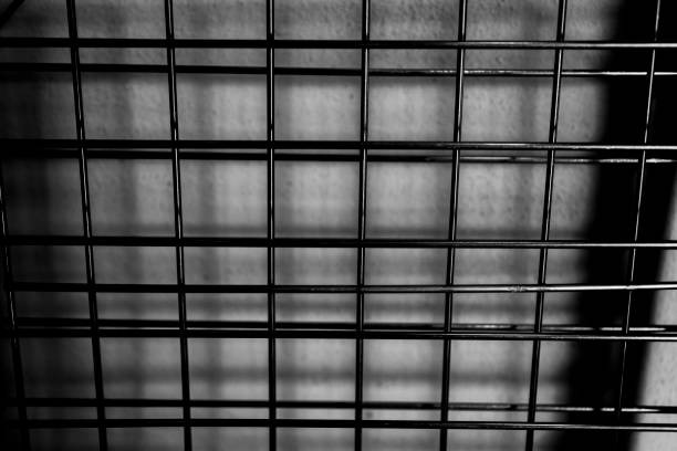 Jail cell with shadows and wall in background of windowed area