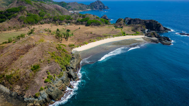 istock Aerial view of a small, empty tropical beach surrounded by blue ocean (Semeti Beach, Lombok) 2156056555
