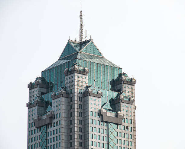 A Skyscraper with blue glass windows and a tower on top of it