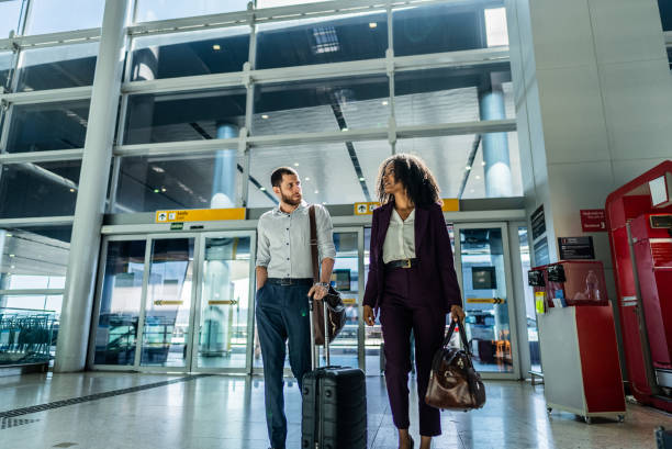 istock Coworkers talking while walking at the airport 2156060074