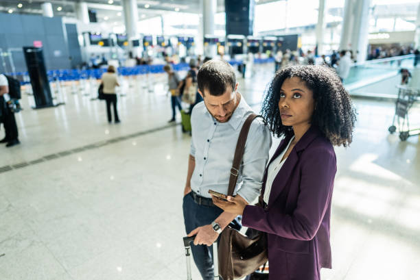istock Coworkers using the mobile phone to check flight informations at the airport 2156060105