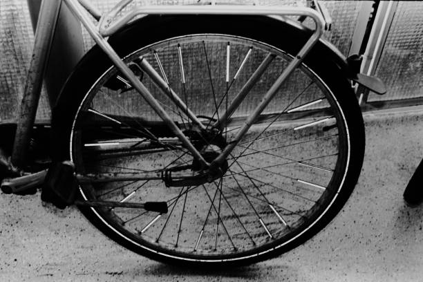 A monochrome image of a bicycle parked against a wall