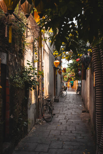 istock Cycles and yellow lanterns in a brick alley 2156060868