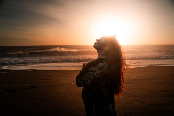 istock Female in dark attire illuminated by sunlight overhead 2156062167