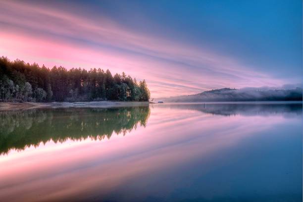 istock Tranquil water reflects a pink sunset sky 2156062412
